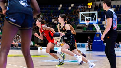 UC Capitals player driving to the basket for a layup during a WNBL game.