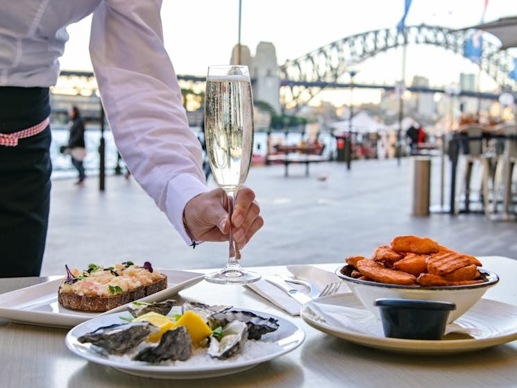 Eastbank Cafe outdoor table set up with oysters and starters overlooking the Sydney Harbour Bridge