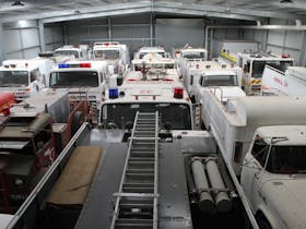 Interior of the Vehicle Pavilion, a large galvanised shed chock full of parked fire appliances.s