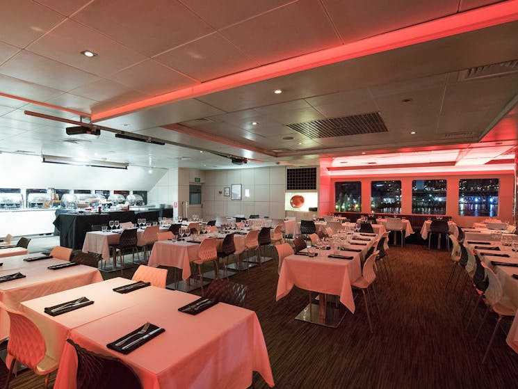 Spacious dining saloon with panoramic windows aboard the Magistic harbour cruise.