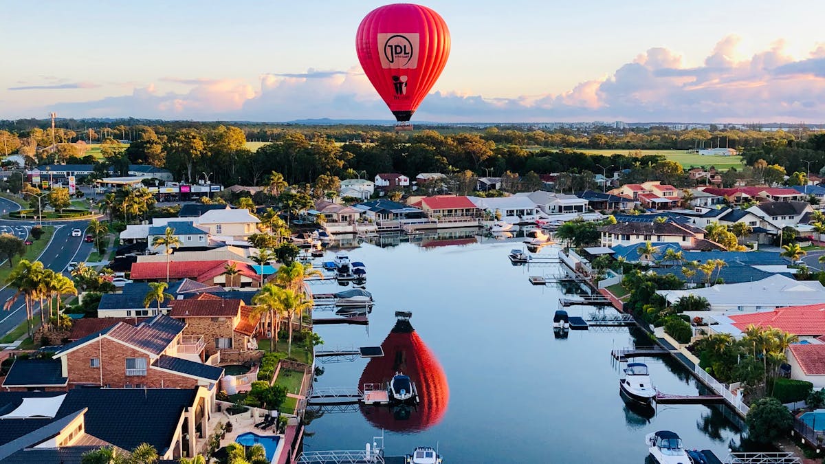 Coastal mirror shot, balloon floating  over houses and canals