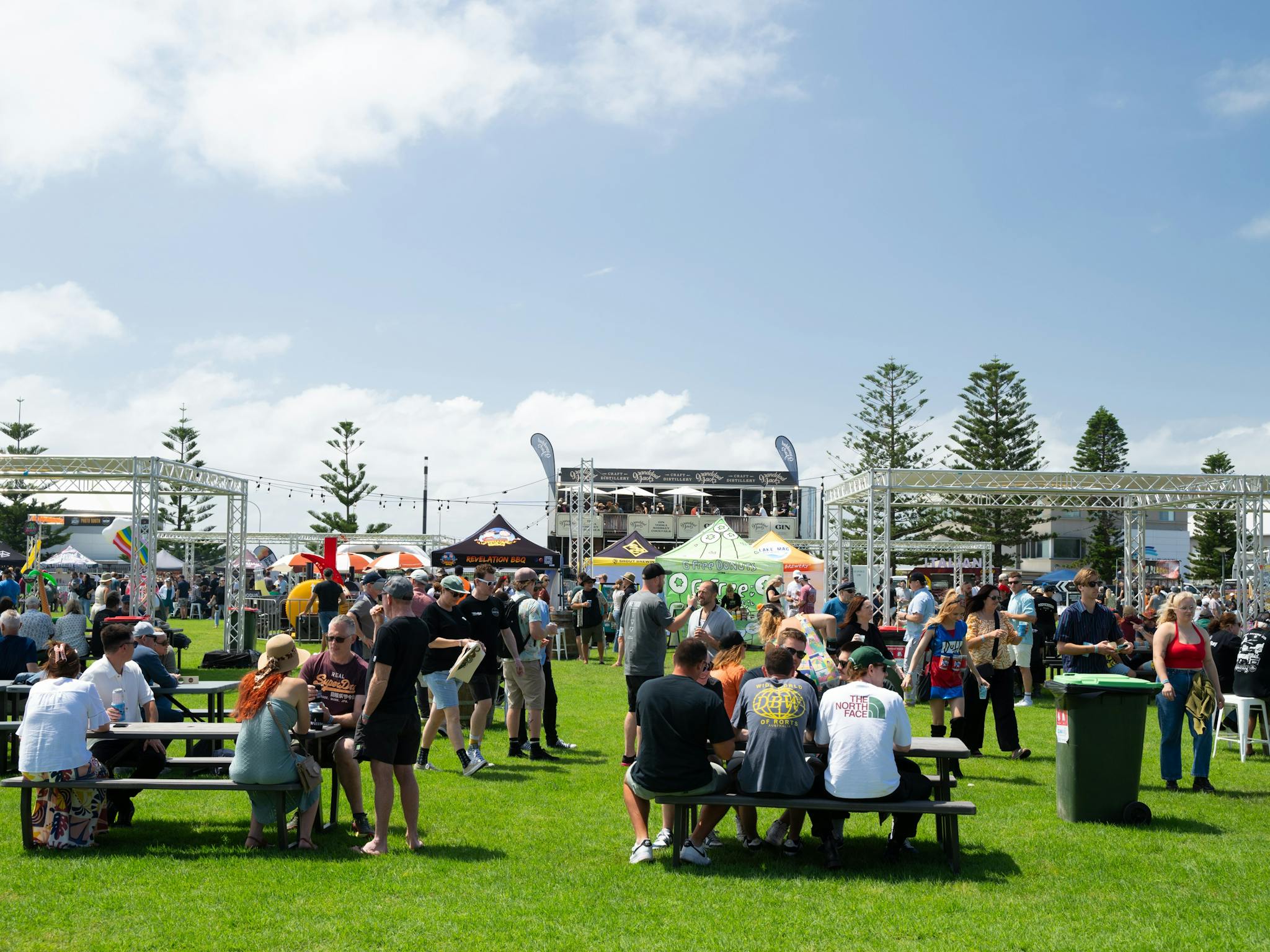 A crowd shot of Crafted Beer Festival showing people sitting at tables in the sunshine drinking beer