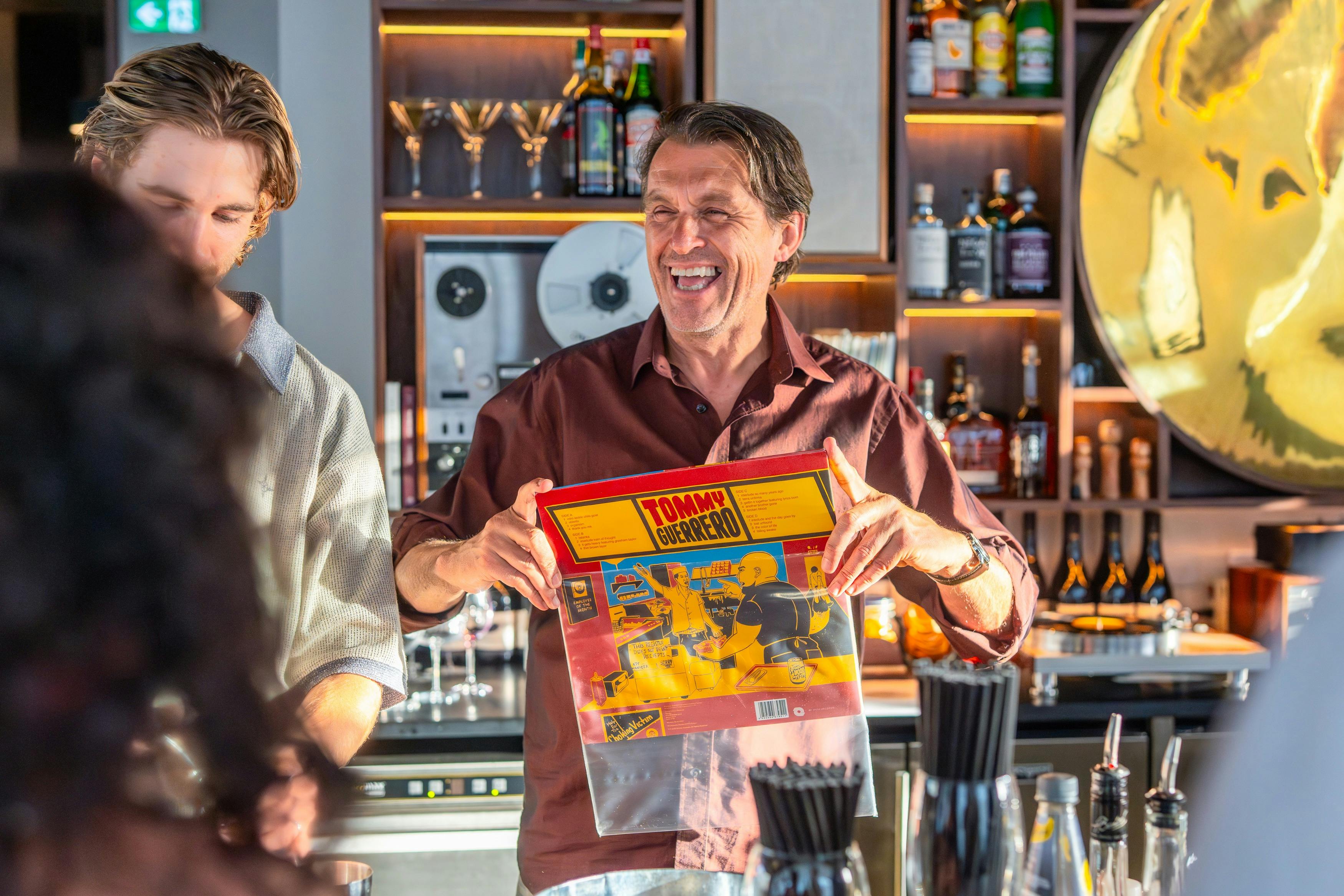 Dill Pickle Club bartender holding a record