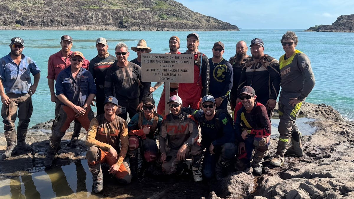 Riders standing with the sign at the tip of Australia Riders standing with the sign at the tip of Australia