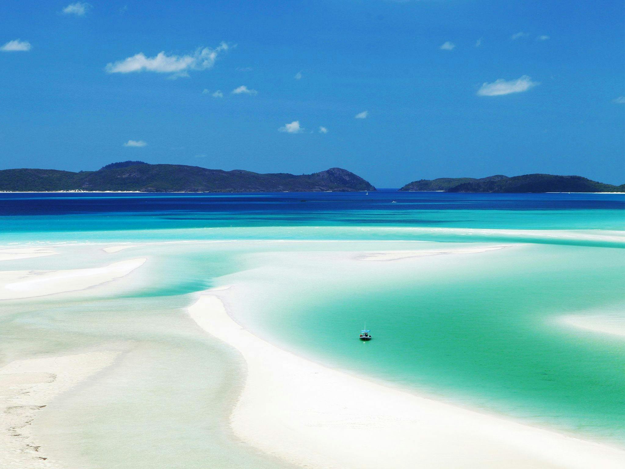 Looking out over white sand and turquoise water to islands in the distance. Looking out over white sand and turquoise water to islands in the distance.