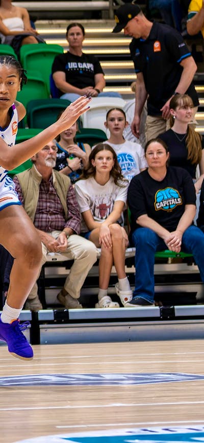 UC Capitals player driving to the basket to complete a layup.