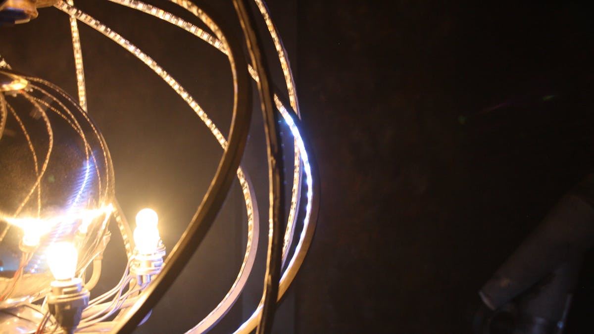 A black background with a glowing illuminated mirror ball and radiation shielding around it.