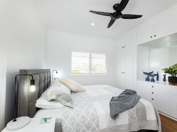Master bedroom with King bed, ceiling fan, and beautiful coastal themed decor