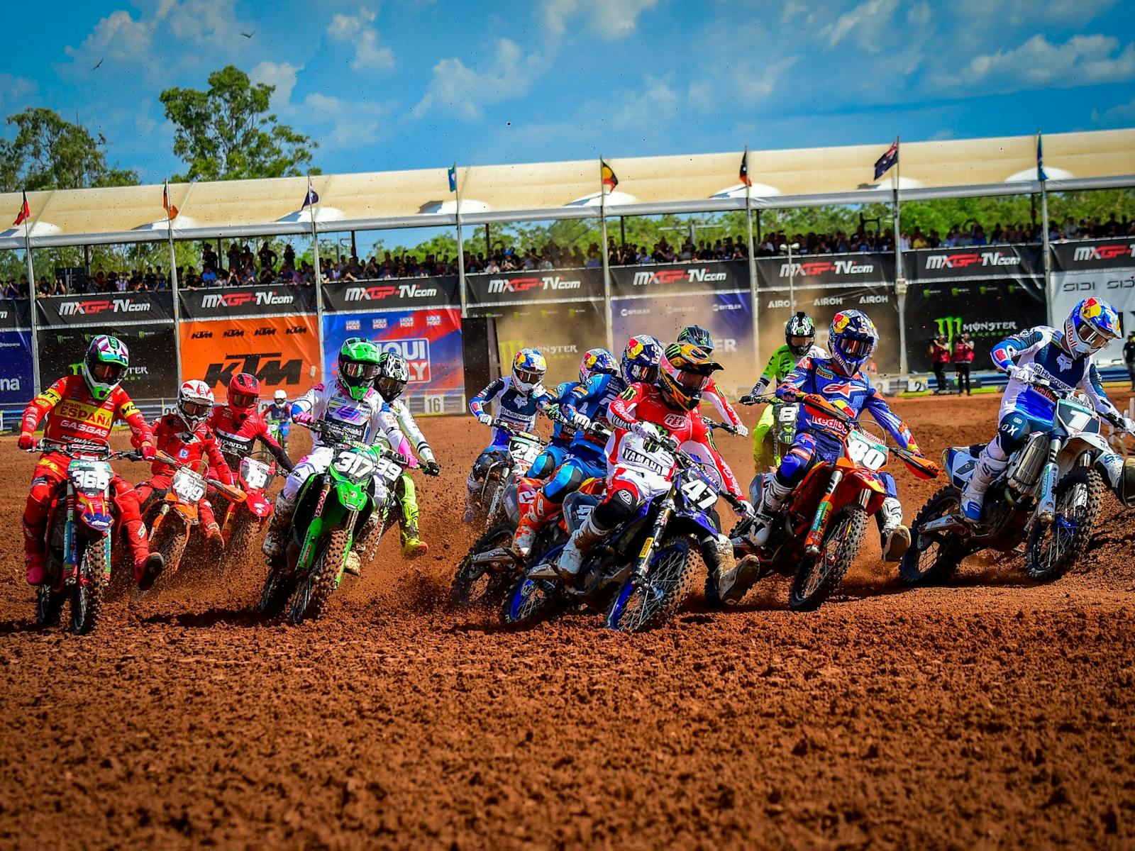 MXGP riders in a group just after start line on bike on track