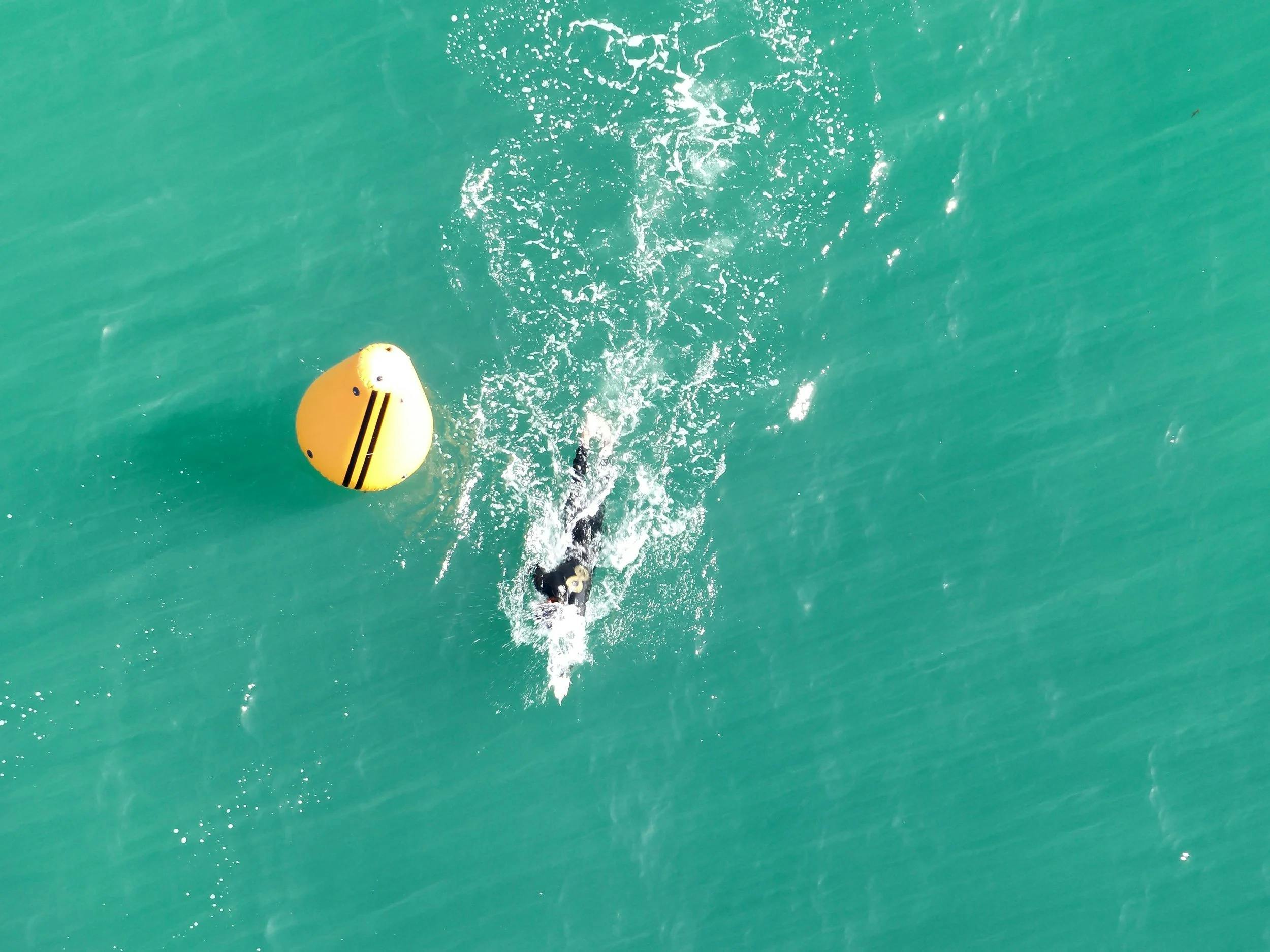 Aerial shot of a participant swimming past a buoy
