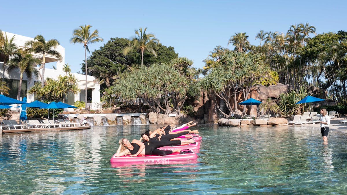 Women doing a side lying classical mat Pilates exercise on Aqua Sculpt boards at a Gold Coast hotel