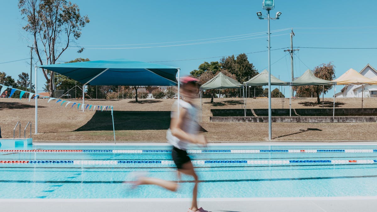 Boy running past the Texas Swimming Pool
