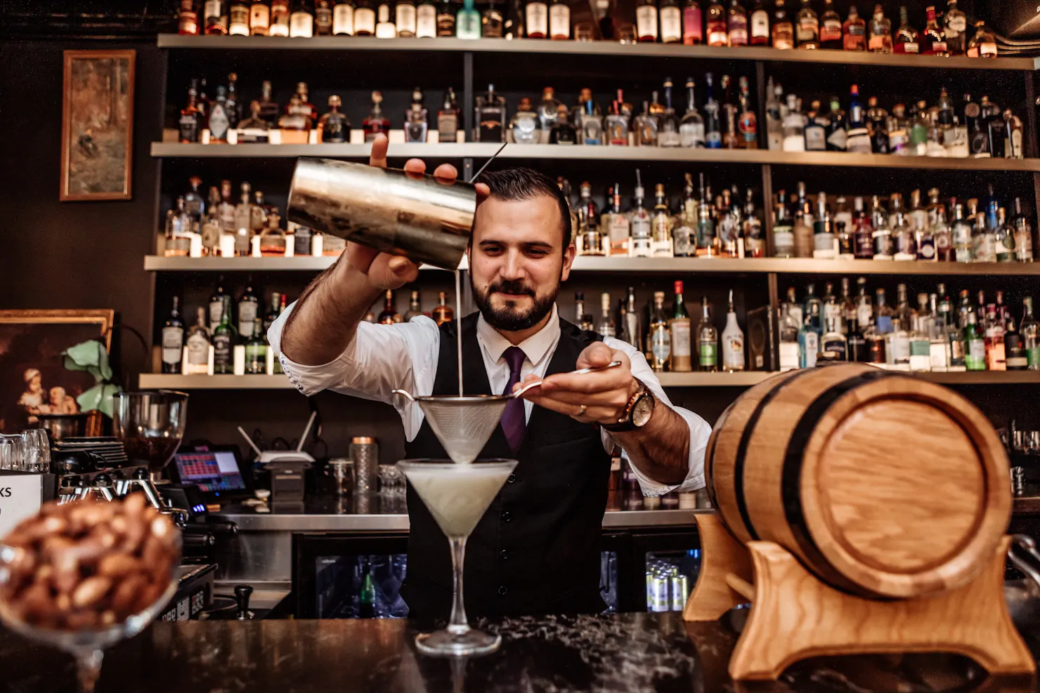 Bartender pouring a cocktail from a Boston Shaker Tin