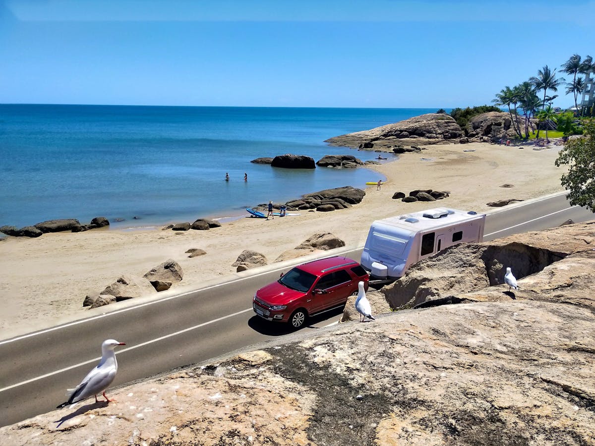 caravan being towed near beachside road