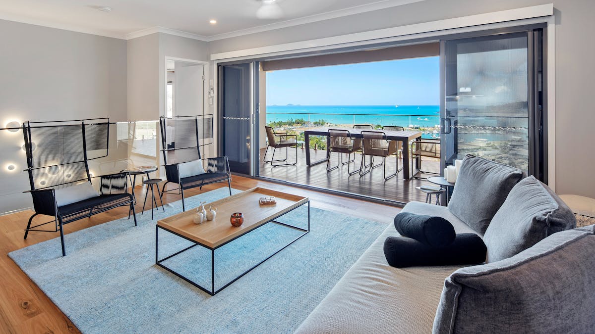 spacious living room opening up to a big balcony and stunning ocean views