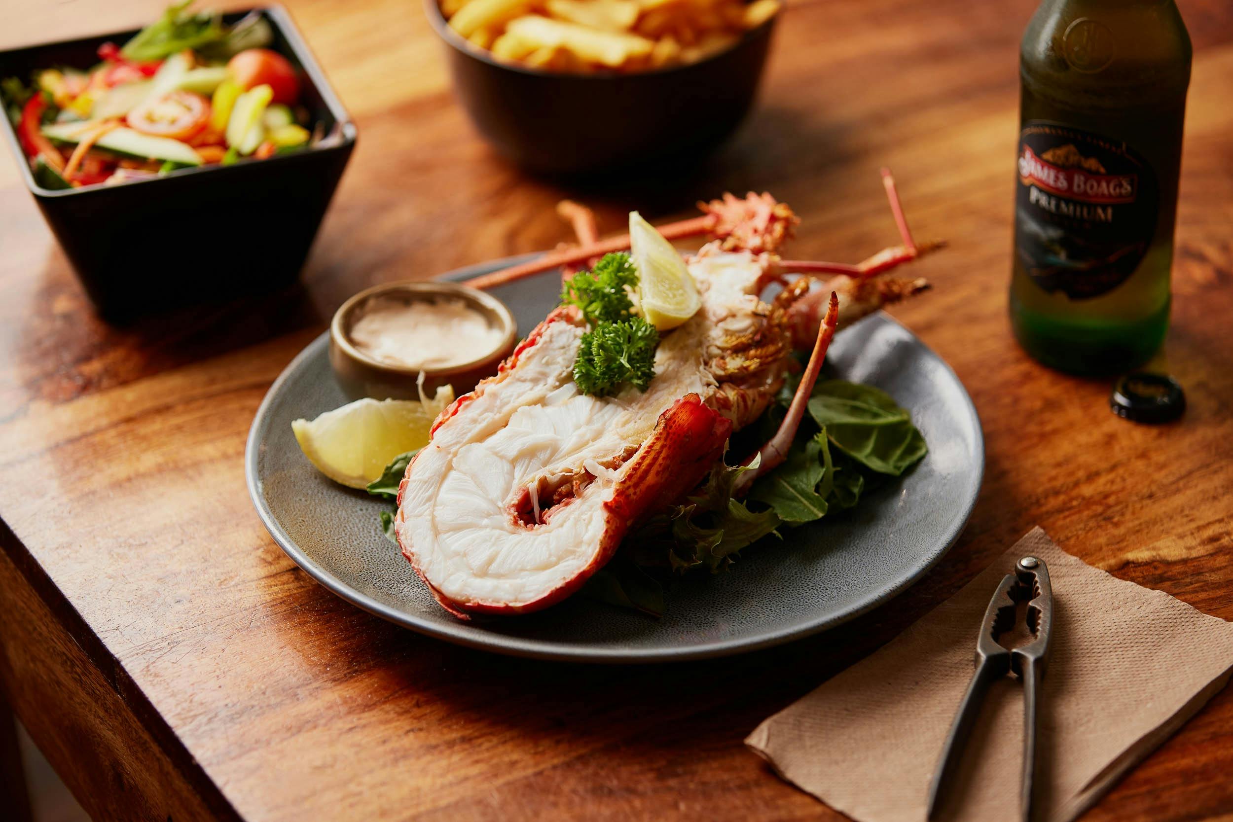 A plate with half a Tasmanian Southern Rock Lobster (crayfish), chips and salad
