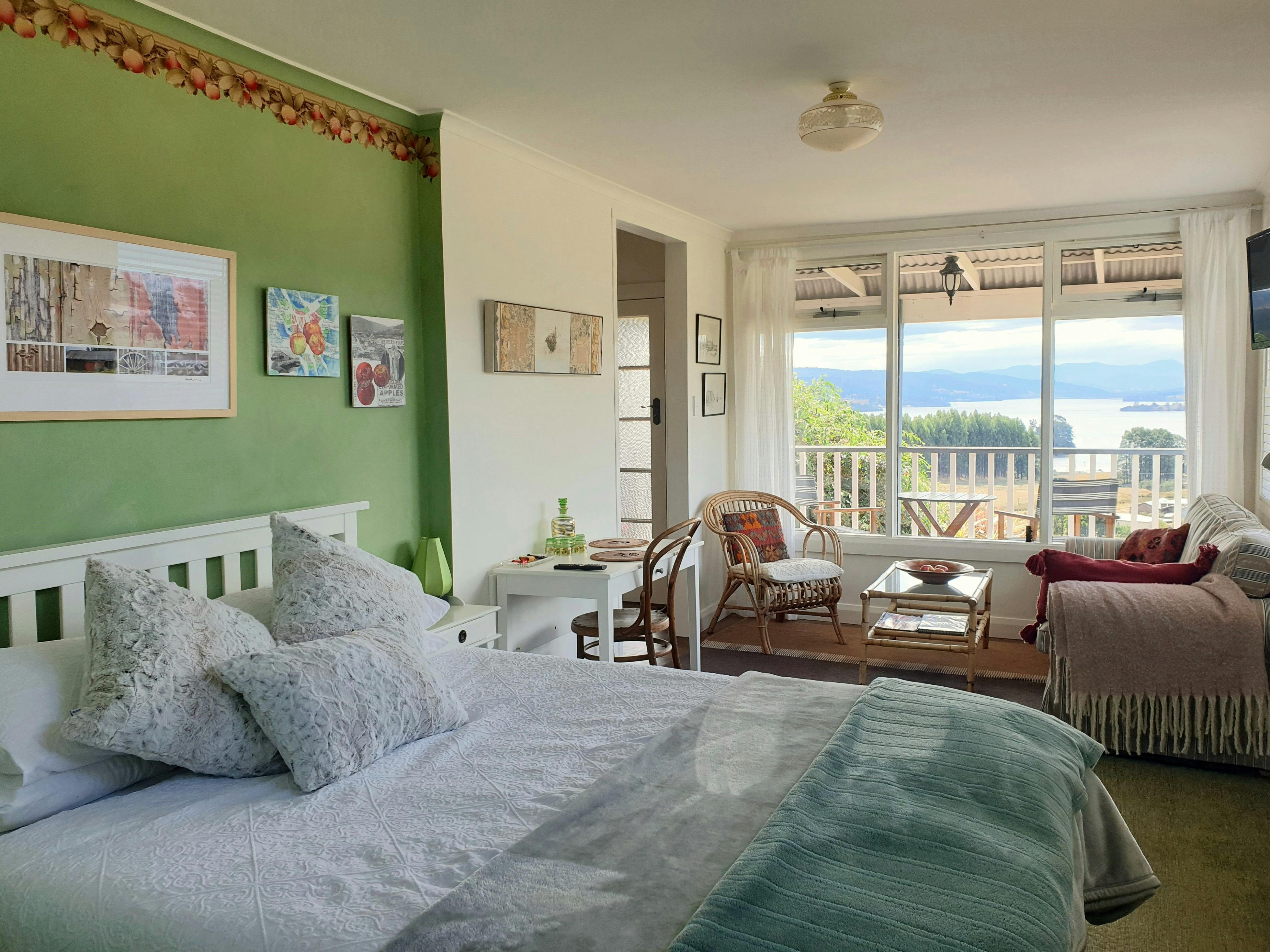 Queen bed with water views through large window.