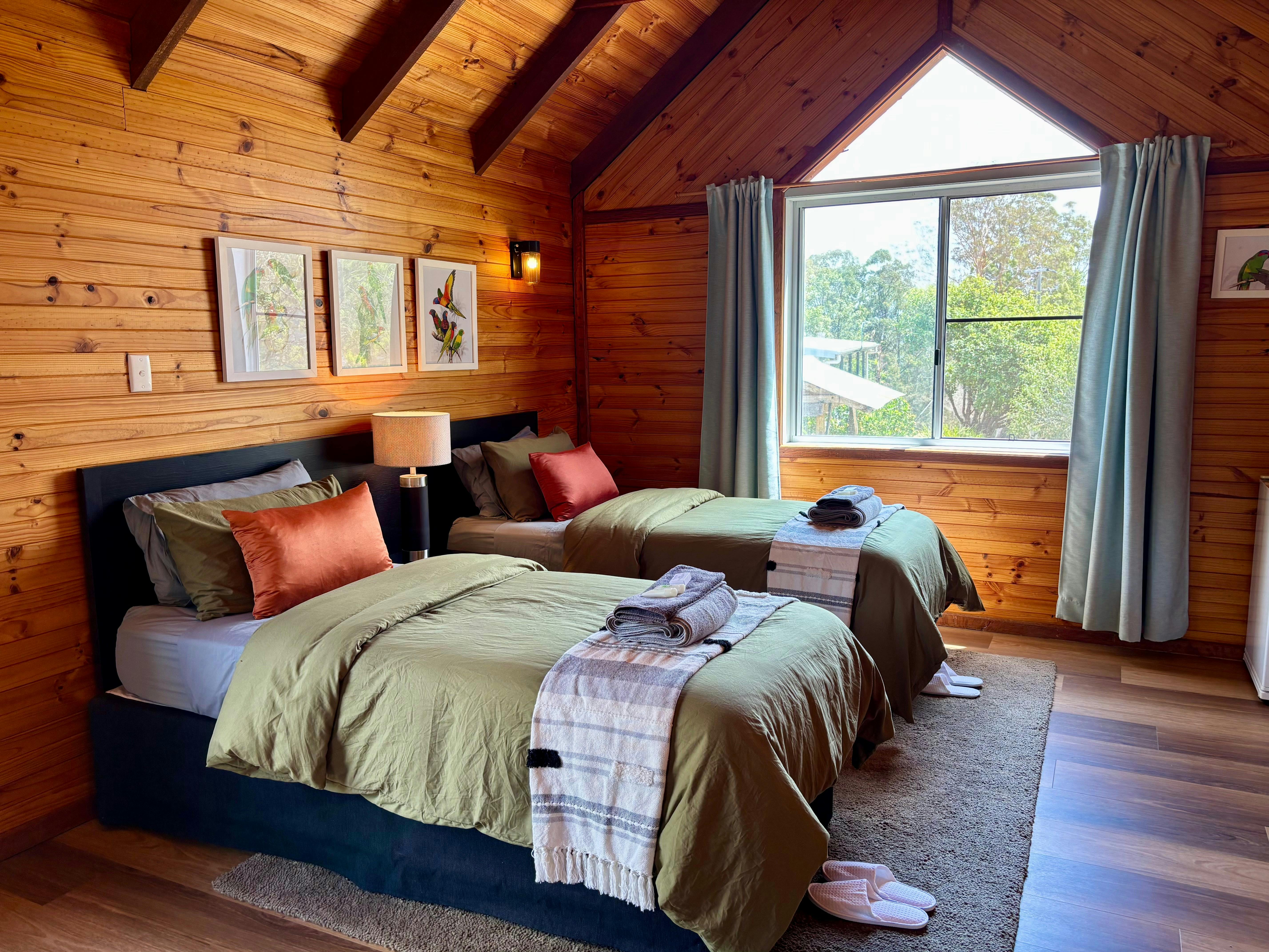 Twin single beds in a chalet room with beautiful natural timber and exposed beams