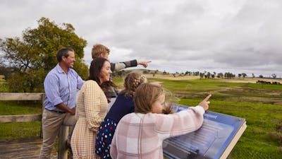 family pointing at wind turbines