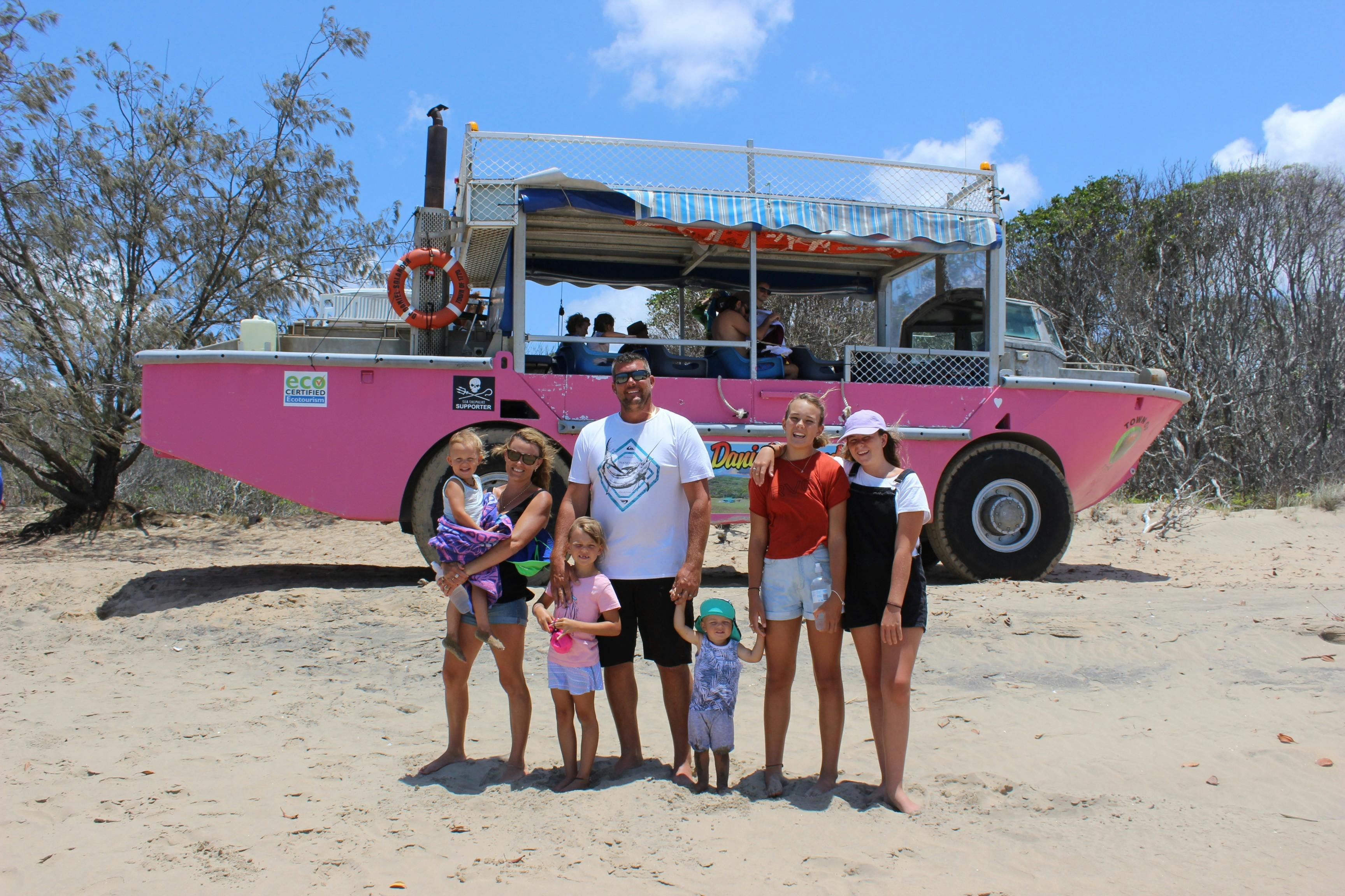 Family standing in front of pink LARC on the beach