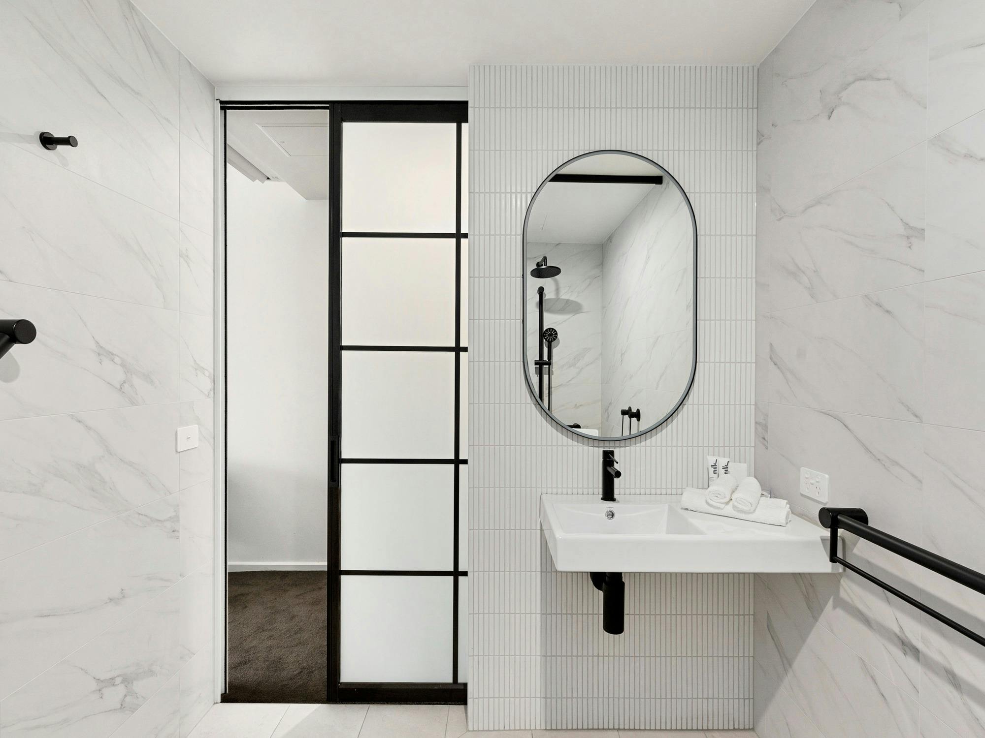 Detail shot of bathroom vanity and sliding door from bedroom