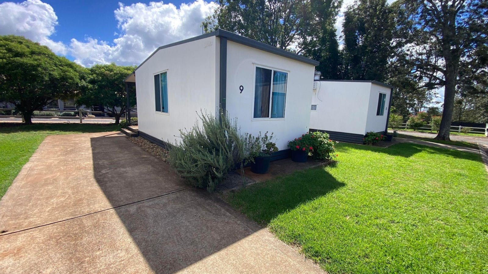 Family Cabin surrounded by green lawns and trees at Yarraman Caravan Park and Cabins. Family Cabin surrounded by green lawns and trees at Yarraman Caravan Park and Cabins.