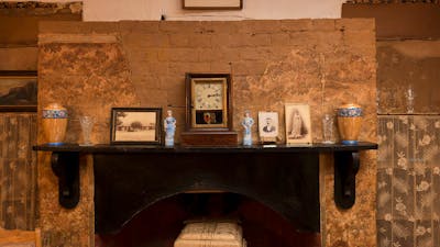 Fireplace in Mugga-Mugga cottage with historical photographs and objects