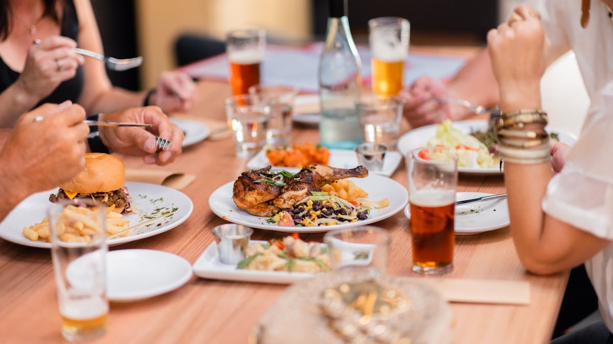 A spread of burgers and main meals on a set table.