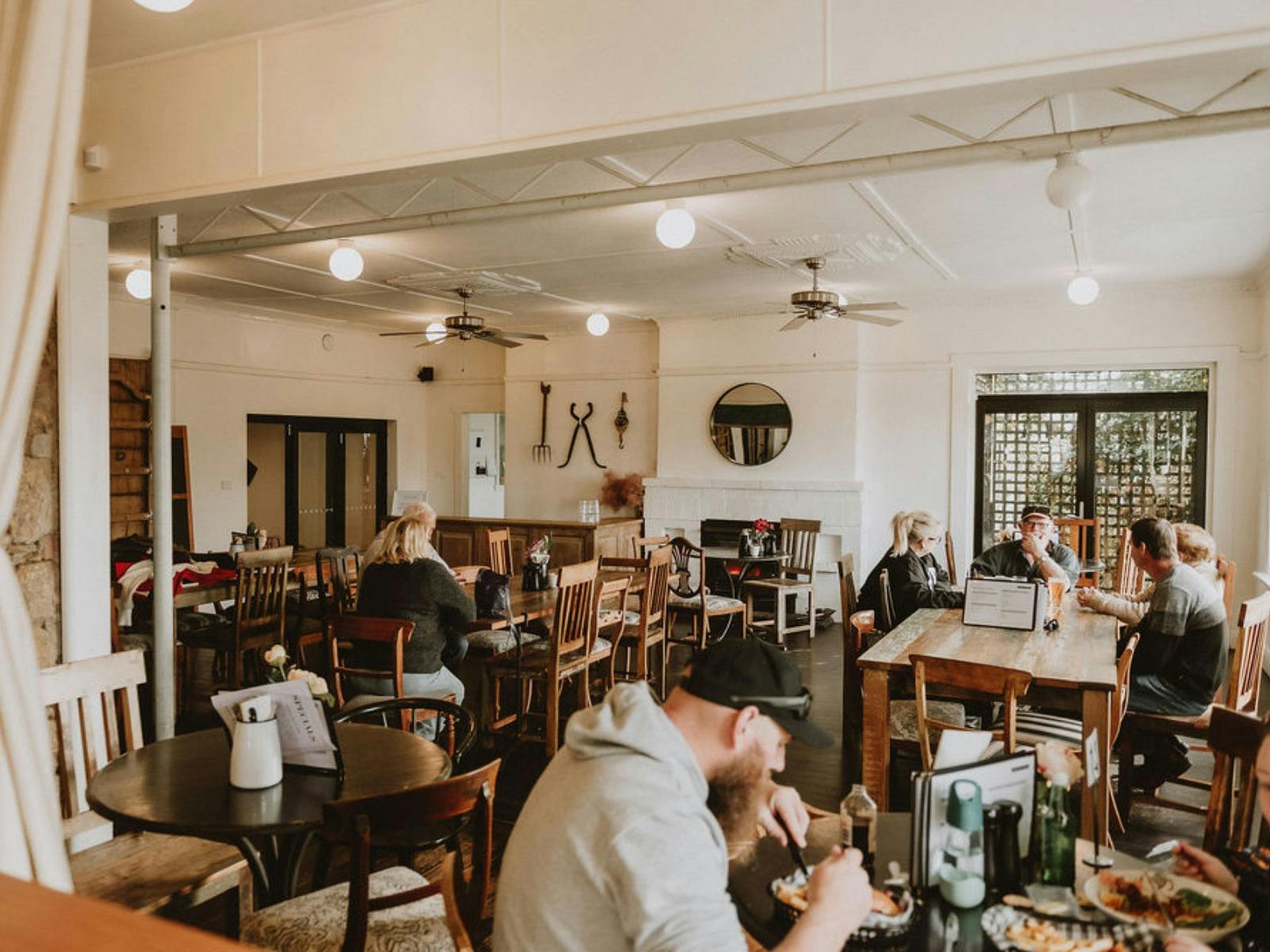 A modern pub dining room with people seated, eating and drinking