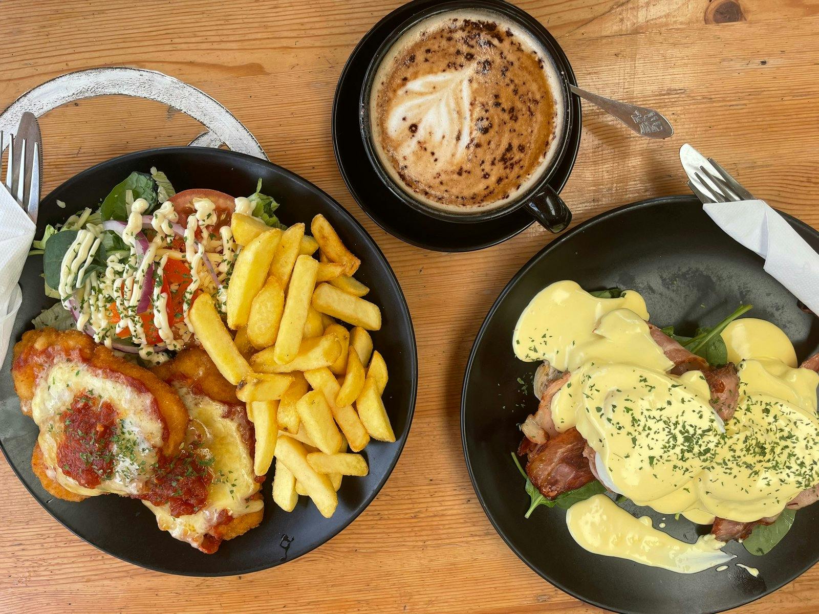 Chicken schnitzel with chips and salad, coffee and eggs Benny with bacon Chicken schnitzel with chips and salad, coffee and eggs Benny with bacon