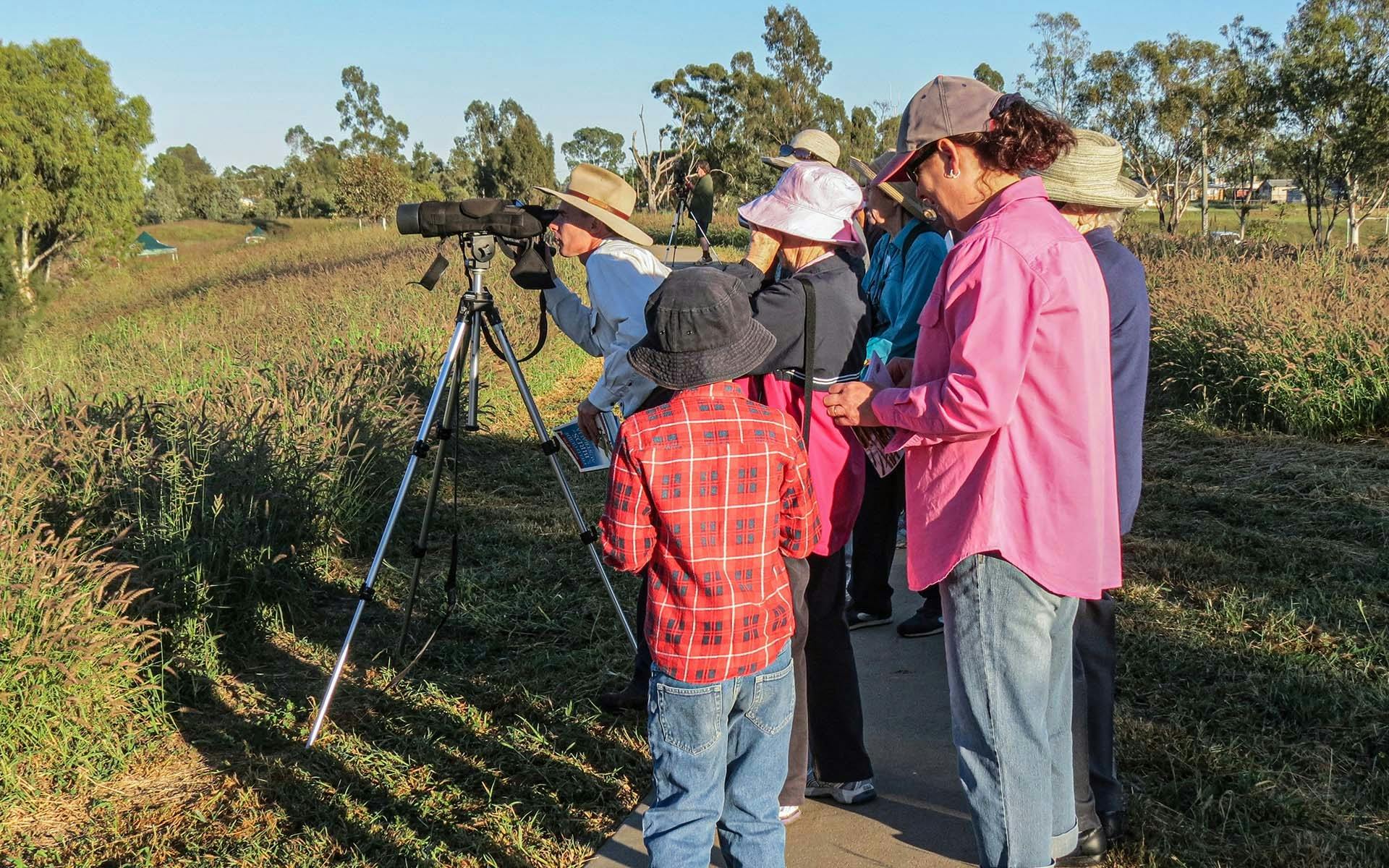 a group of guests crowded around a camera