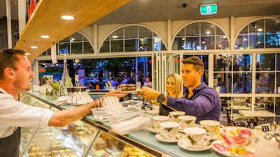 Couple couple being served cake over the counter