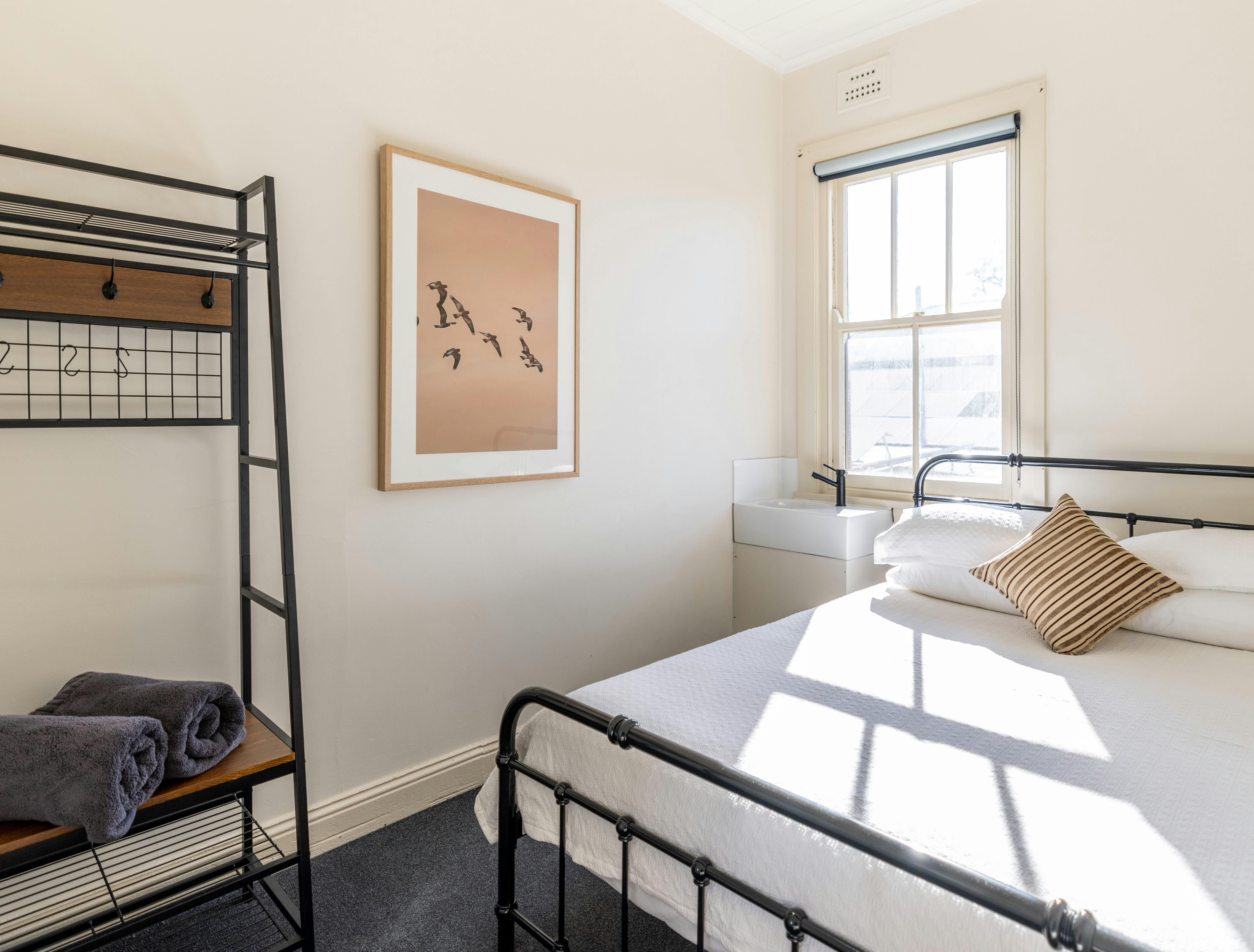 Queen Room with hang cupboard, photo, sink and bed.