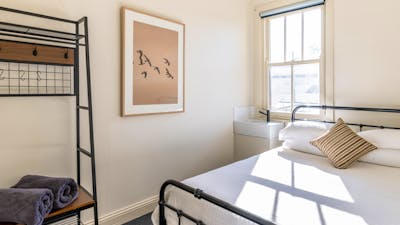 Queen Room with hang cupboard, photo, sink and bed.