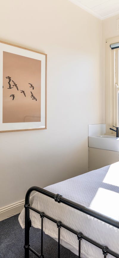 Queen Room with hang cupboard, photo, sink and bed.