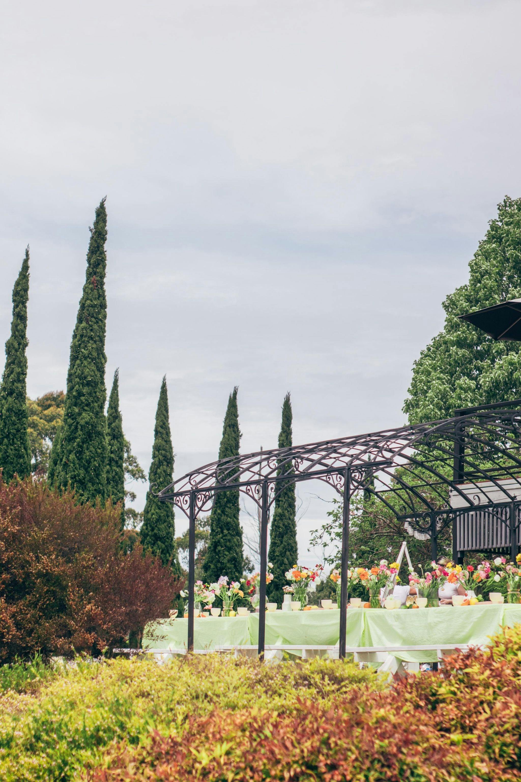 A photo of a table of flowers under a gazebo