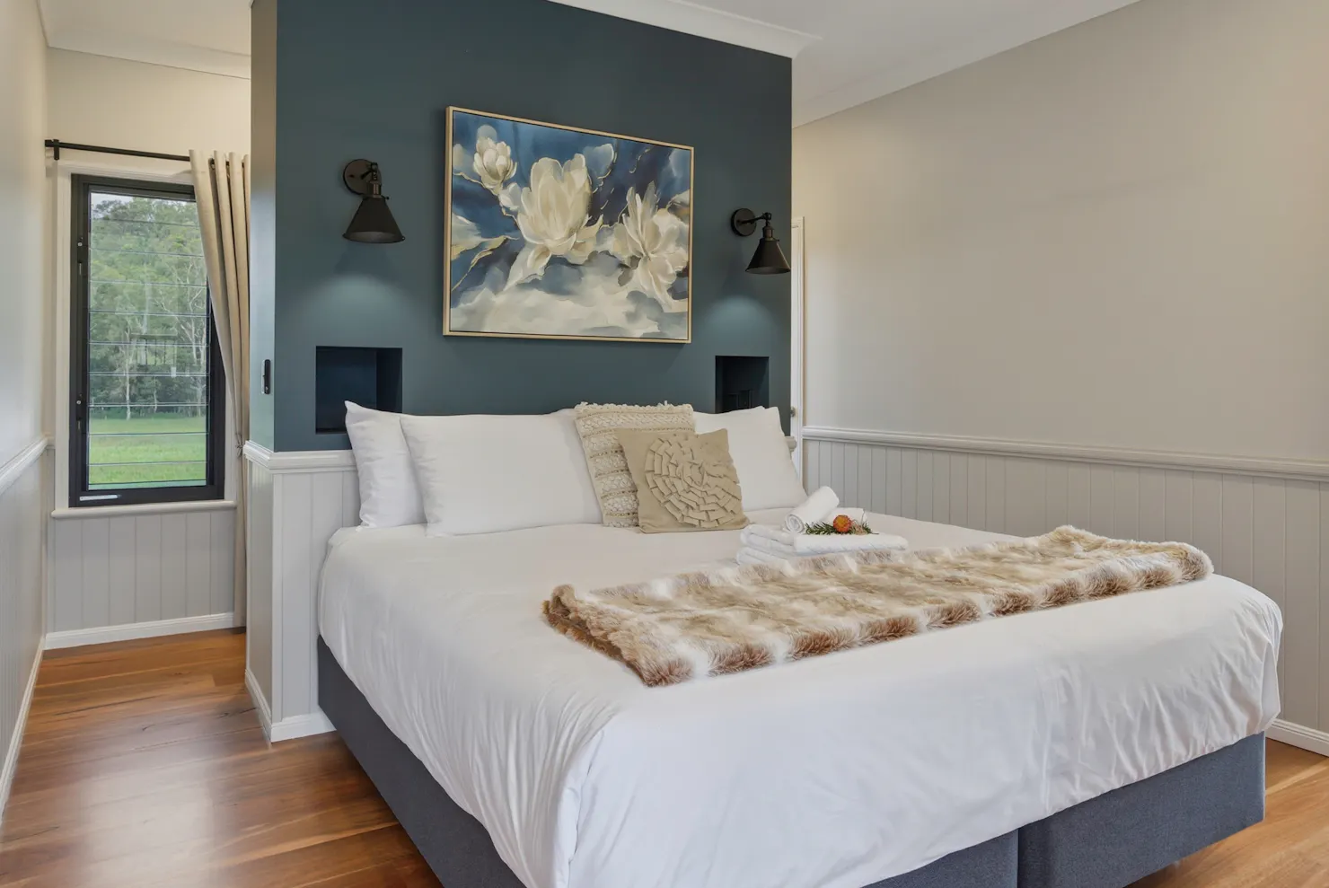 King bedroom with white linens, feature wall, and soft lighting in Maleny Lodge