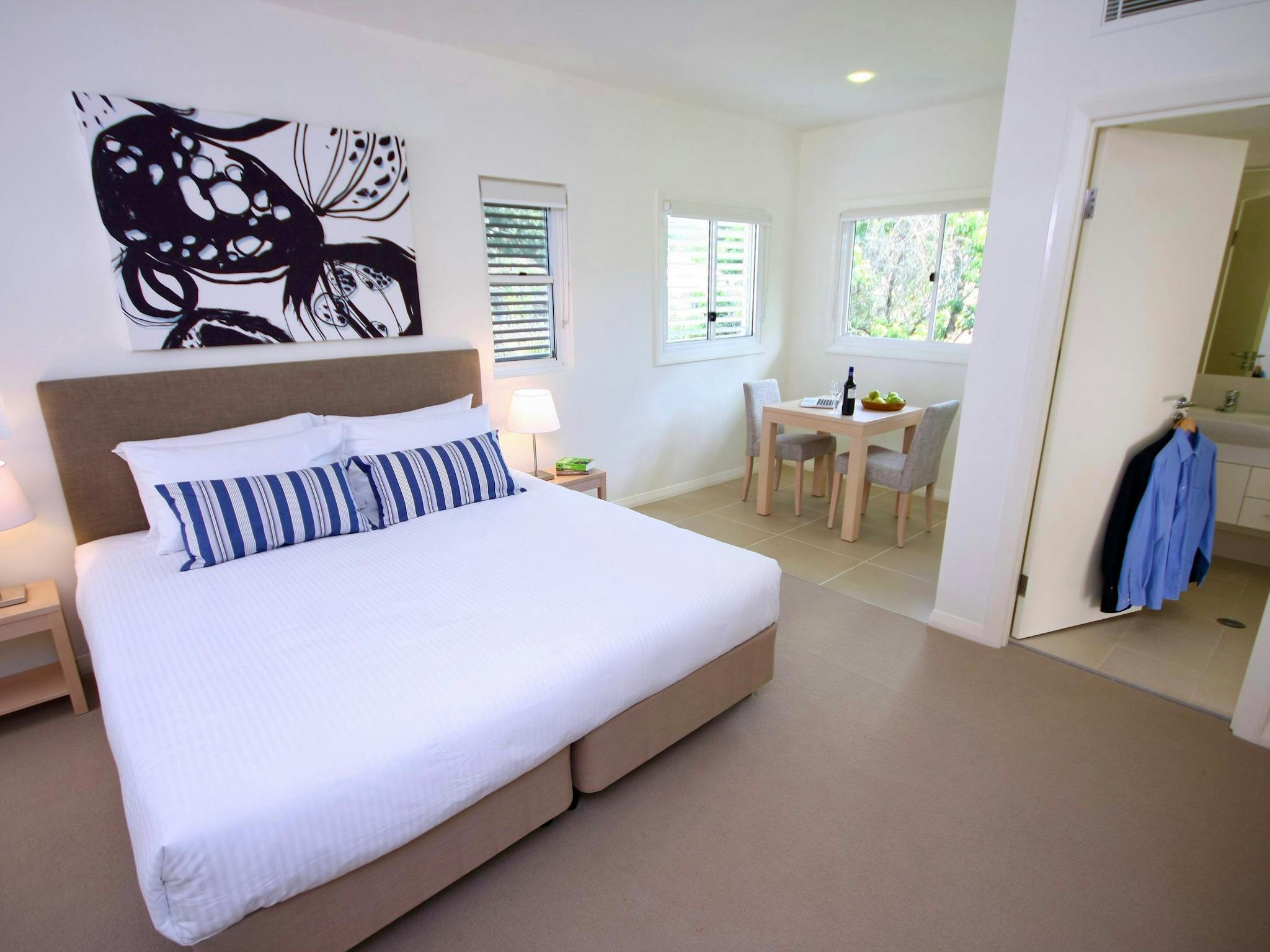 Spacious ground floor studio with king bed, blue striped cushions, abstract wall art, dining table, Spacious ground floor studio with king bed, blue striped cushions, abstract wall art, dining table,
