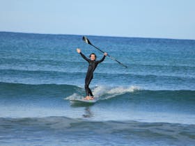 Beginner SUP Surfer catching his first wave