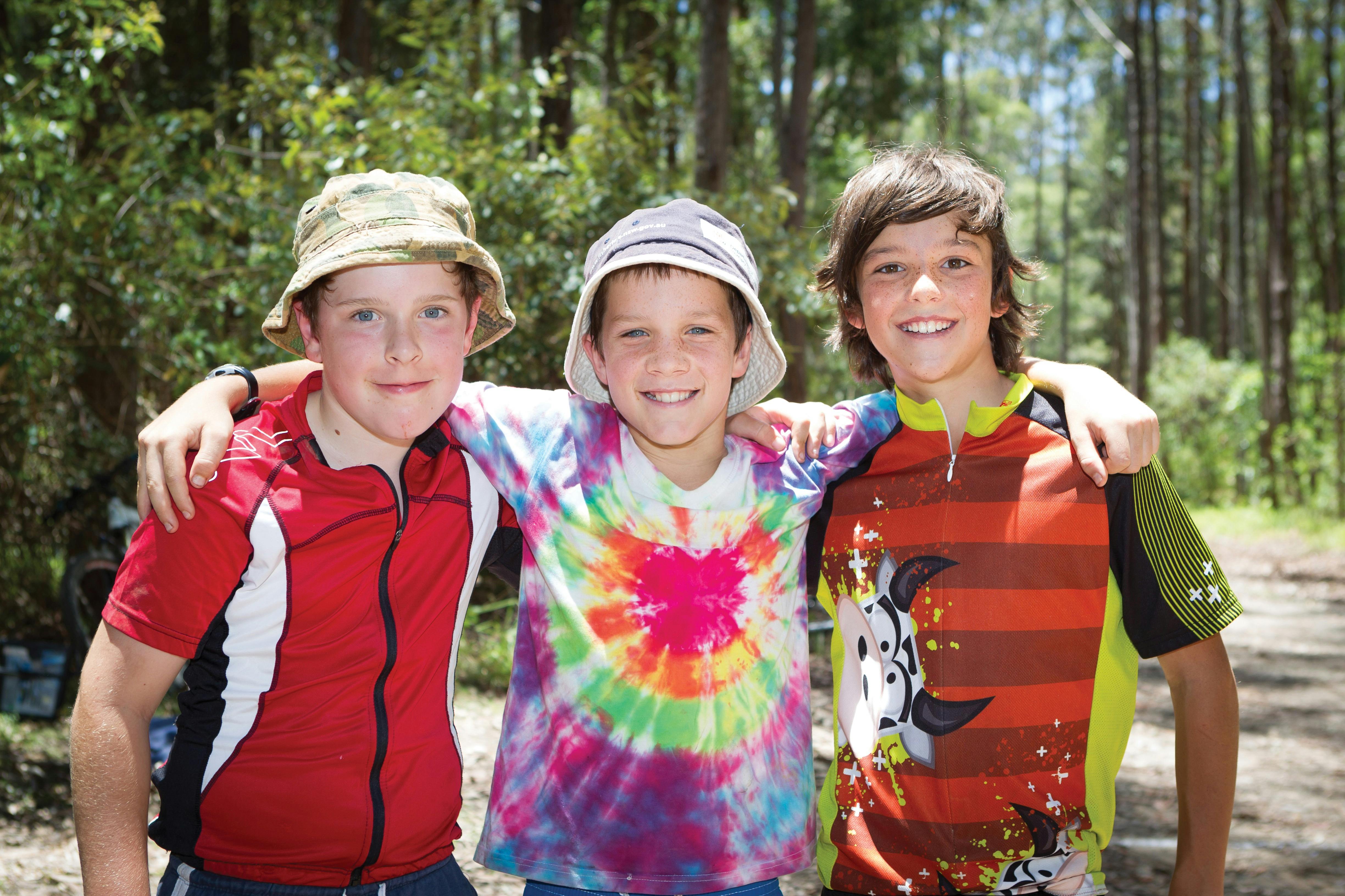 Three boys in Pine Creek State Forest smiling at the camera
