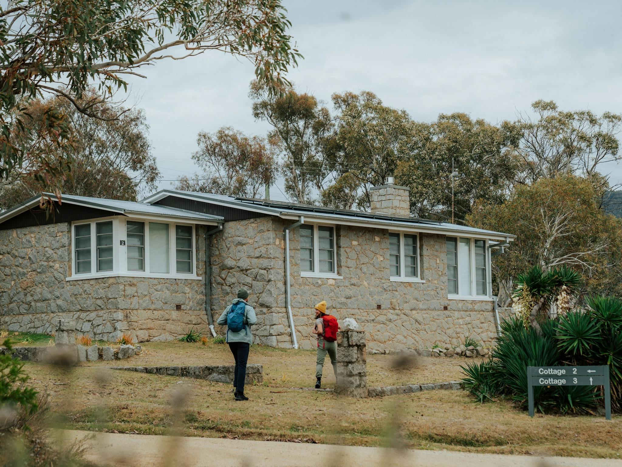 Two walkers outside Creel Bay Cottages on the Snowies Alpine Walk.