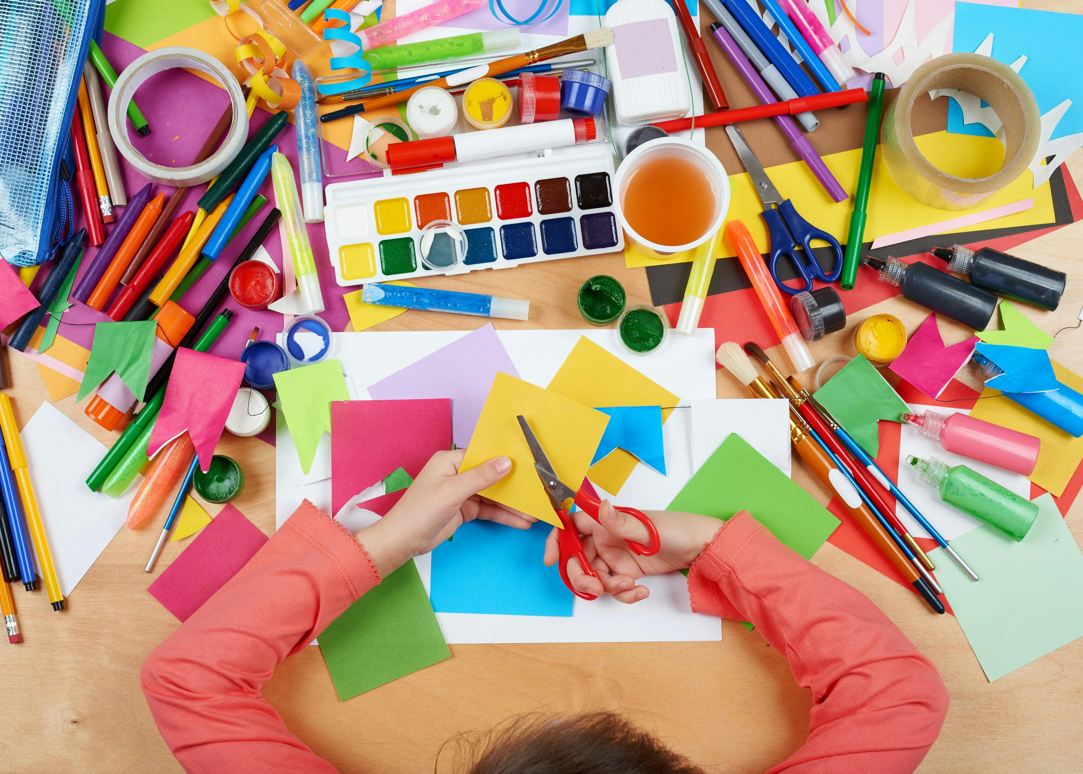 A child works with a variety of colourful craft materials