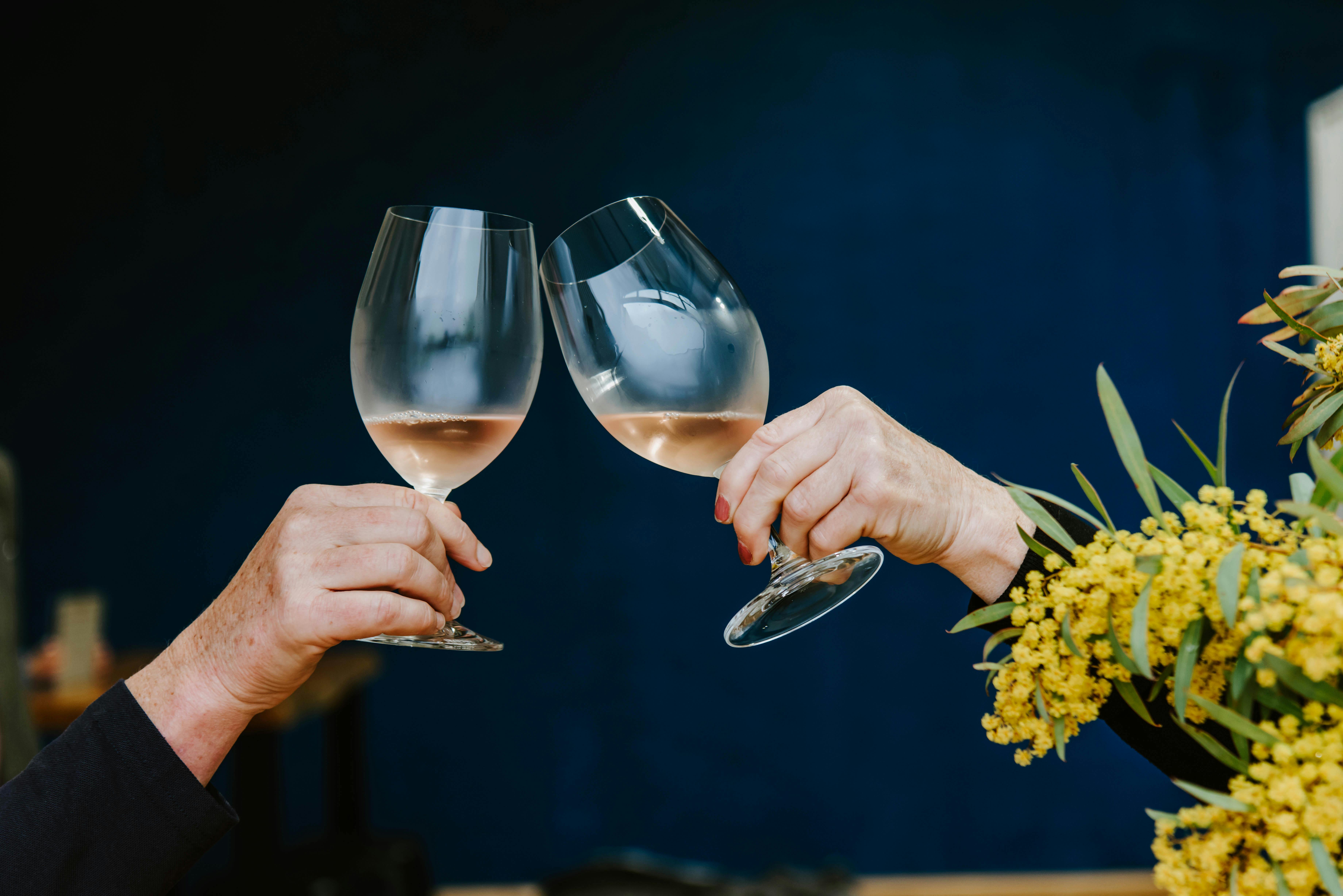 McIntosh Estate Rose being cheered against the blue wall at the cellar door.