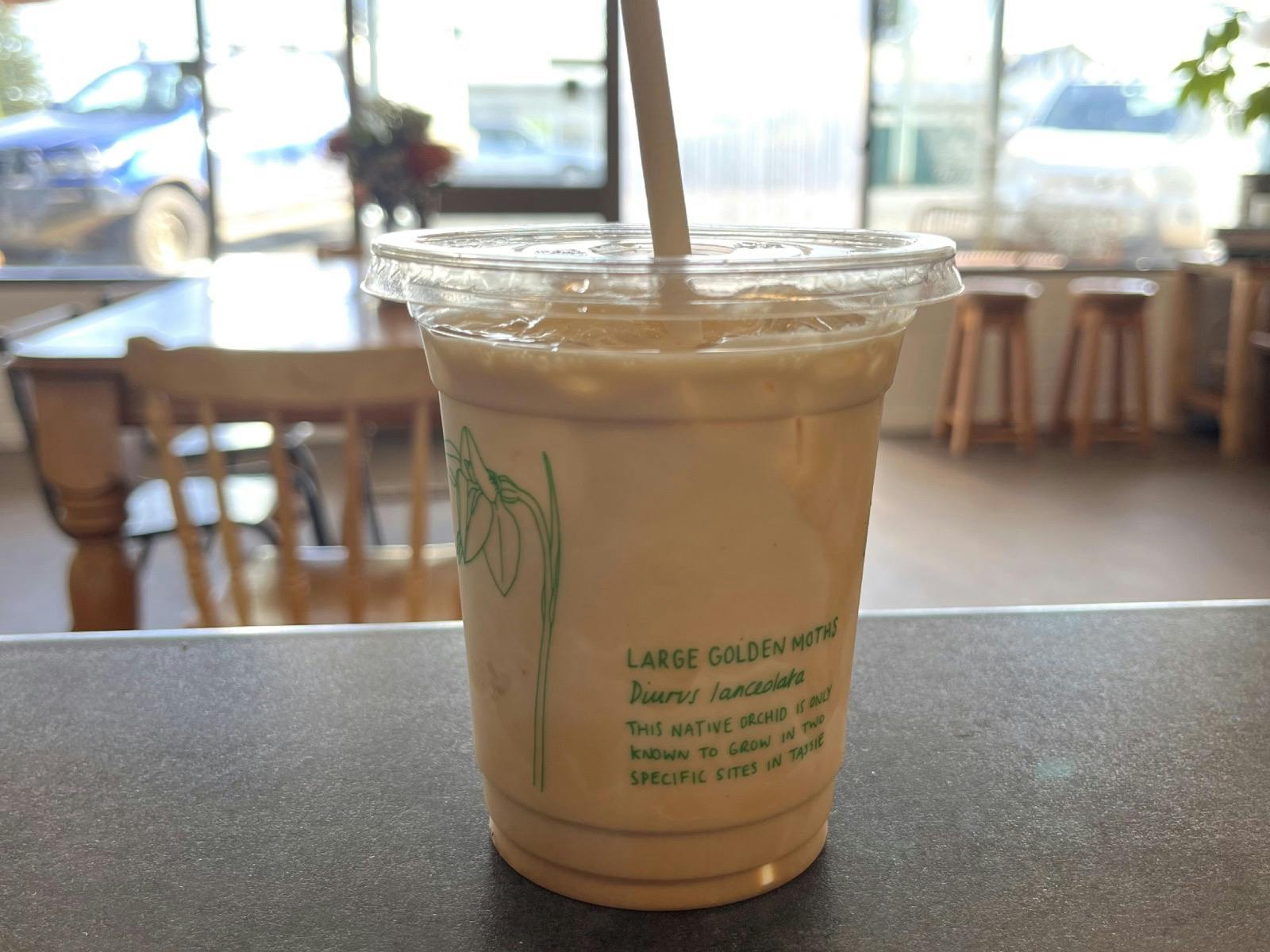 Iced Latte in takeaway cup sitting on bench