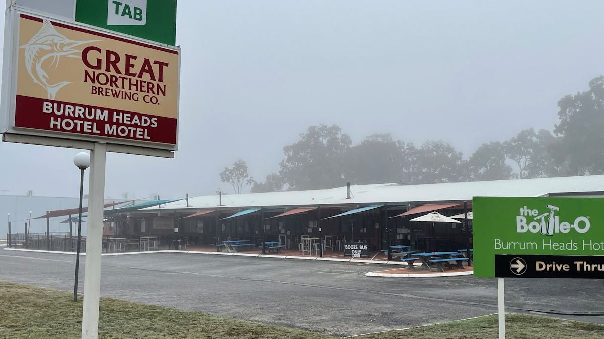 phot of Burrum Heads Hotel Motel with signs on a very foggy morning in June