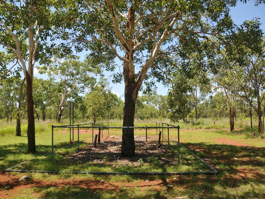 Cemetery site defined by a concrete kerb and steel fence. A shade shelter is outside the cemetery.