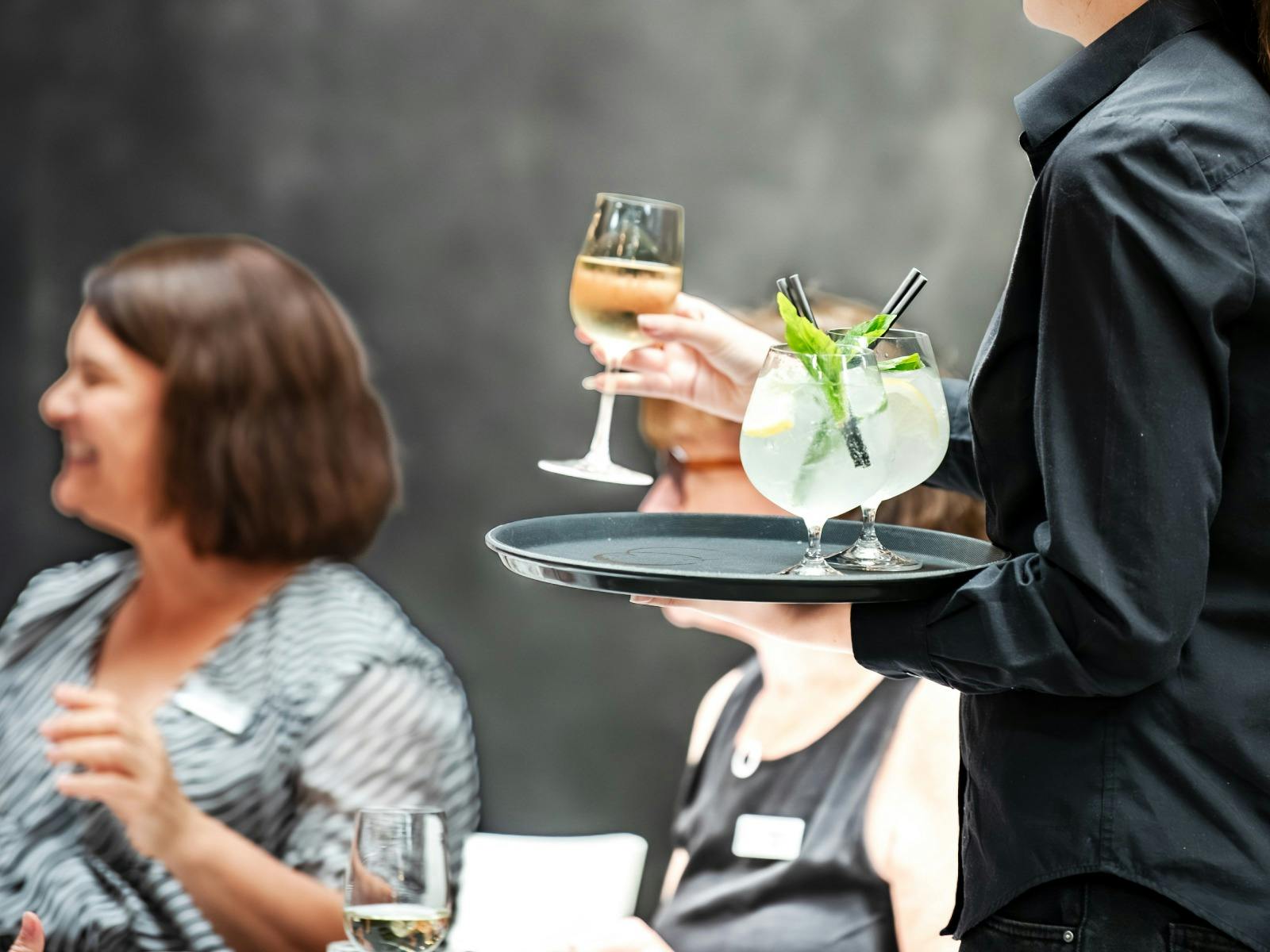 An Earp Distilling Co. employee serves a tray of refreshing sprtizes at an event