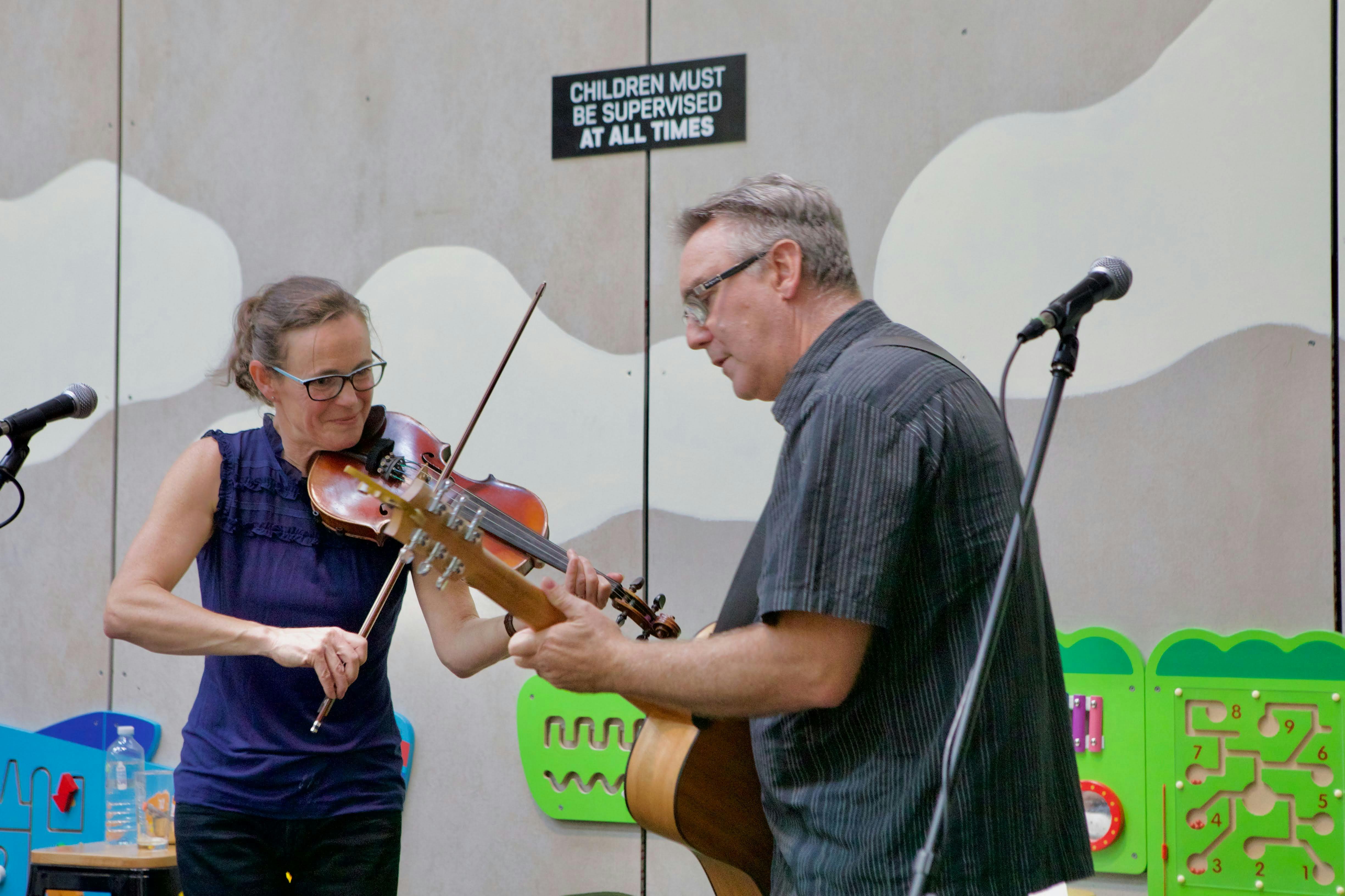 Female violinist and male guitarist on stage