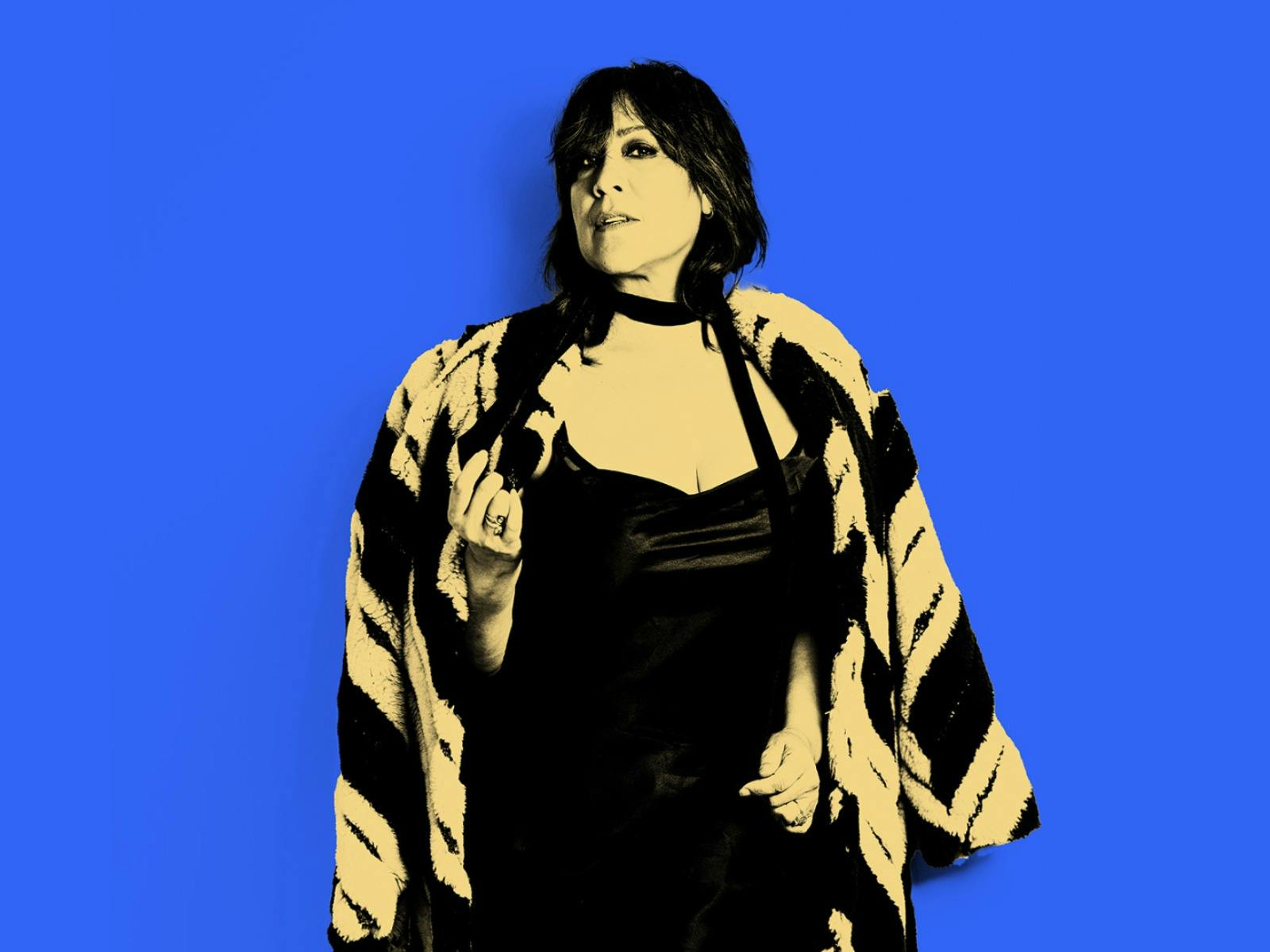 The incredible Kate Ceberano standing in front of a vibrant blue background