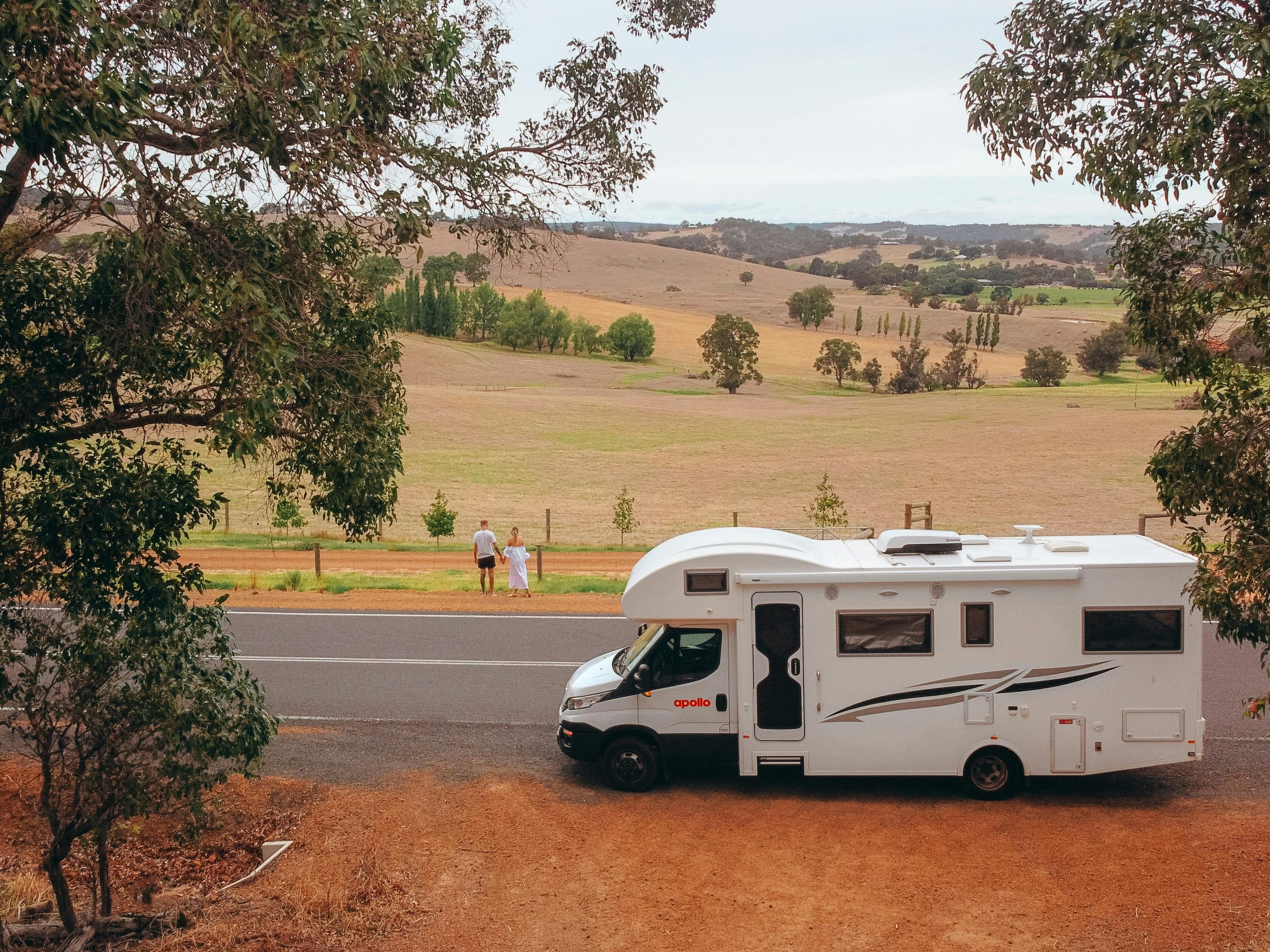 A young couple pull over their motorhome to look at the fields